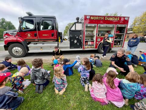 children with firefighters and fire truck