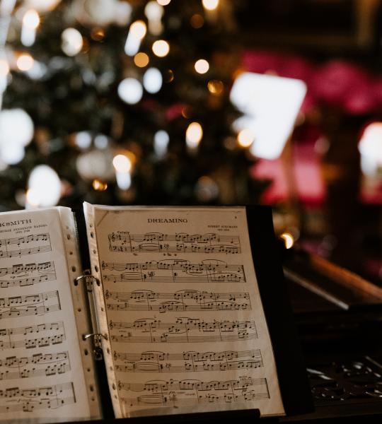 sheet of music with Christmas tree in the background