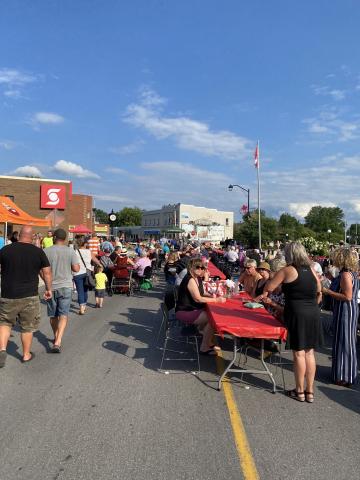 People eating at street table at MMOMS Chesterville