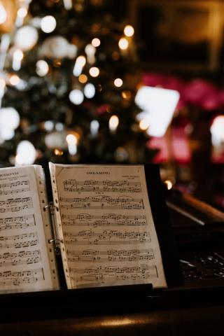 sheet of music with Christmas tree in the background